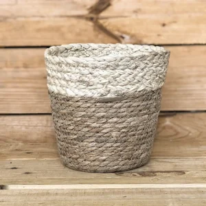 Macetero de anea y maíz natural con un acabado trenzado y tonos neutros que aportan calidez y un toque rústico a la decoración de tu hogar. Su diseño natural es perfecto para vestir tus plantas y crear ambientes acogedores.